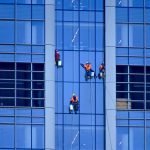 Employés nettoyants des vitres en hauteur