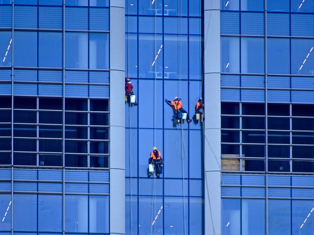 Employés nettoyants des vitres en hauteur