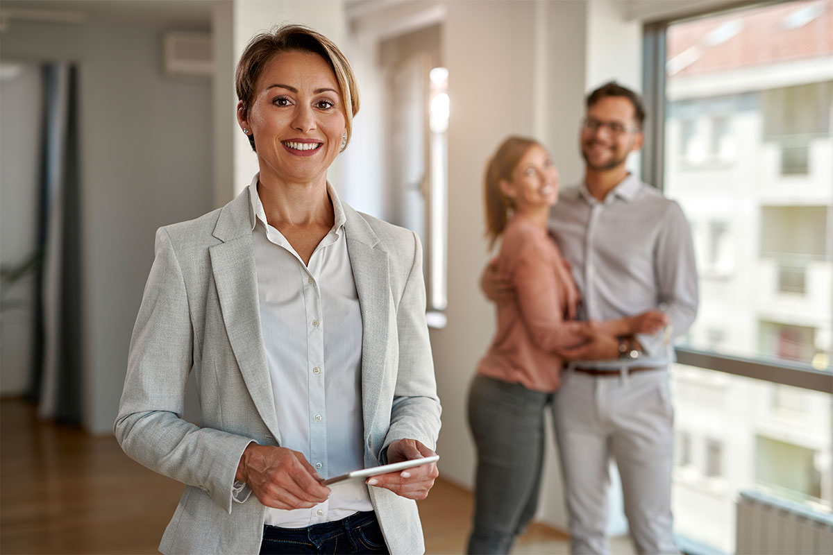 Agent immobilier devant couple sur le point d'acheter